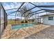 Screened-in pool with brick patio and a view of the back yard at 10060 Amelia Ave, Englewood, FL 34224