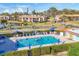 Aerial view of community pool with residents enjoying a swim and the surrounding landscape, showcasing community amenities at 11 Quails Run Blvd # 9, Englewood, FL 34223