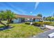 Exterior of community clubhouse featuring well-maintained landscaping, seating, and a welcoming entrance at 11 Quails Run Blvd # 9, Englewood, FL 34223