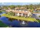 Beautiful condo building with a pond and water feature, surrounded by lush landscaping and mature trees at 11 Quails Run Blvd # 9, Englewood, FL 34223