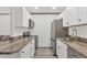 Galley kitchen featuring stainless steel appliances and countertops at 11 Quails Run Blvd # 9, Englewood, FL 34223