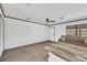 Bright living room features a ceiling fan, neutral paint, plank floors, and a large window at 11 Quails Run Blvd # 9, Englewood, FL 34223