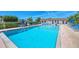 Community pool area with clear water, lounge chairs, and shaded seating creating a perfect relaxation spot at 11 Quails Run Blvd # 9, Englewood, FL 34223