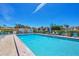 Community pool featuring sparkling blue water, lounge chairs, and manicured landscaping for relaxation at 11 Quails Run Blvd # 9, Englewood, FL 34223