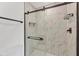 Elegant bathroom shower with sleek marble tile, frameless door, and stylish black fixtures at 11 Quails Run Blvd # 9, Englewood, FL 34223