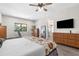 Spacious main bedroom with wood-look floors, large windows, and a view into the home at 11085 Sunnydale Ave, Englewood, FL 34224