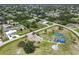 A lovely aerial view of a community with houses, a playground, a sports court, and green spaces under a blue sky at 11101 Sandrift Ave, Englewood, FL 34224