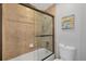 Bathroom featuring a shower tub with tile backsplash and a glass door at 11101 Sandrift Ave, Englewood, FL 34224