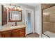 Bathroom with a wood vanity, glass enclosed shower and access to the backyard at 11101 Sandrift Ave, Englewood, FL 34224