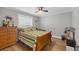 A comfortable bedroom with a wooden bed frame, ceiling fan, and natural light at 11101 Sandrift Ave, Englewood, FL 34224
