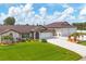 Well-maintained front yard with lush green grass, updated landscaping, and an expansive three-car garage at 11101 Sandrift Ave, Englewood, FL 34224