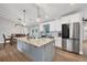 Contemporary kitchen with a large island, white cabinets, stainless steel appliances, and dining space at 11101 Sandrift Ave, Englewood, FL 34224