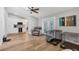 Bright living room featuring wood floors, ceiling fan, and open layout to kitchen at 11101 Sandrift Ave, Englewood, FL 34224