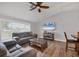 Comfortable living room features a plush sofa, wood flooring, and a large window for natural light at 11101 Sandrift Ave, Englewood, FL 34224