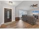 Cozy living room with wood floors, a decorative front door and a ceiling fan at 11101 Sandrift Ave, Englewood, FL 34224