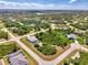 Aerial view of neighborhood with lush landscaping; a home with a pool is featured at 115 Australian Dr, Rotonda West, FL 33947
