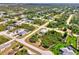 Aerial view of a neighborhood showcasing a home with a screened-in pool and lush landscaping at 115 Australian Dr, Rotonda West, FL 33947