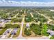 Aerial view showcases this neighborhood's home with screened-in pool and lush landscaping at 115 Australian Dr, Rotonda West, FL 33947