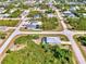 Aerial view of a neighborhood, highlighting a home with a screened-in pool and lush landscaping at 115 Australian Dr, Rotonda West, FL 33947