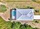 Overhead view of a home's roof and screened-in pool in a tropical setting at 115 Australian Dr, Rotonda West, FL 33947