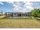 Home's backyard features a screen enclosed lanai, pool, and a partially landscaped yard at 115 Australian Dr, Rotonda West, FL 33947