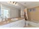 Bright bathroom features a white vanity, large mirror, and a shower/tub combo with tile surround at 115 Australian Dr, Rotonda West, FL 33947