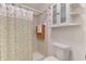 Bathroom showcases a shower with floral curtain, plus a toilet and storage cabinet at 115 Australian Dr, Rotonda West, FL 33947