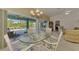 Dining room with a glass table and wicker chairs, offering picturesque views of the pool and lanai at 115 Australian Dr, Rotonda West, FL 33947