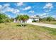 Well-maintained single-story home boasting a neat lawn and mature palm trees in a sunny locale at 115 Australian Dr, Rotonda West, FL 33947