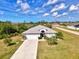 Aerial view of a beautifully landscaped one story home with a white exterior and arched entryway at 115 Australian Dr, Rotonda West, FL 33947
