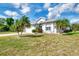 Well maintained single-story home with manicured lawn, landscaping, and palm trees at 115 Australian Dr, Rotonda West, FL 33947
