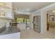 Bright kitchen featuring stainless steel refrigerator, white cabinetry, and an adjacent dining area with pool views at 115 Australian Dr, Rotonda West, FL 33947