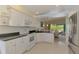 Fully equipped kitchen with white appliances, granite countertops, and views of the backyard dining area at 115 Australian Dr, Rotonda West, FL 33947