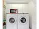 Laundry room with white cabinets, red microwave, and side-by-side washer and dryer at 115 Australian Dr, Rotonda West, FL 33947