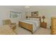 Cozy main bedroom featuring a natural-style bed frame and an adjacent comfortable sitting chair at 115 Australian Dr, Rotonda West, FL 33947