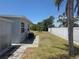 The backyard featuring a white fence, palm tree, and an air conditioning unit at 1160 Sharlo Cir, Englewood, FL 34224