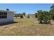 Backyard with green grass and trees with a white house and a satellite dish at 1160 Sharlo Cir, Englewood, FL 34224