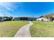 Spacious backyard featuring a screened-in porch, manicured lawn, and concrete pathway leading up to the home at 1278 Lincoln Dr, Englewood, FL 34224