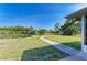 Spacious backyard with a walkway leading to a tranquil pond and lush surroundings at 1278 Lincoln Dr, Englewood, FL 34224
