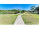 Backyard view featuring a tranquil pond, dock, and lush natural surroundings at 1278 Lincoln Dr, Englewood, FL 34224