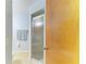 Bathroom featuring a walk-in shower with glass doors, toilet, and wood door at 1278 Lincoln Dr, Englewood, FL 34224