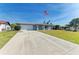 Well-maintained one-story home with a two-car garage, manicured lawn, and a classic American flag at 1278 Lincoln Dr, Englewood, FL 34224