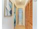 Hallway with wood-look flooring, decorative wall art, and closet with paneled doors leading to bedroom and bathroom at 1278 Lincoln Dr, Englewood, FL 34224
