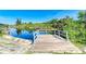 Private backyard wooden dock over the water with white railing, concrete supports, and views of lush trees and blue sky at 1278 Lincoln Dr, Englewood, FL 34224
