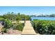 Wooden dock extending into the waterfront with lush greenery at 140 Crestview Dr, Englewood, FL 34223
