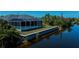Aerial view featuring a waterfront property with screened-in pool, landscaped yard, and private canal access at 14526 Fort Worth Cir, Port Charlotte, FL 33981
