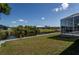 The waterfront backyard features a tranquil pond view with lush landscaping and a screened-in lanai at 14526 Fort Worth Cir, Port Charlotte, FL 33981