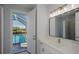 Bathroom featuring a pool view from the door, a mirror, and a white vanity at 14526 Fort Worth Cir, Port Charlotte, FL 33981