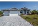 Well designed driveway leading up to a three-car garage, with manicured landscaping at 14526 Fort Worth Cir, Port Charlotte, FL 33981