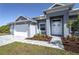 Close up of the front entrance, landscaping, and a three-car garage on a single-story home at 14526 Fort Worth Cir, Port Charlotte, FL 33981